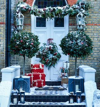 Festive front door with garland and snow
