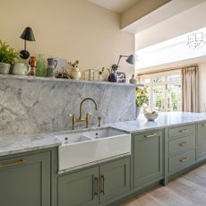 green kitchen cabinetry with sinks and marble worktops