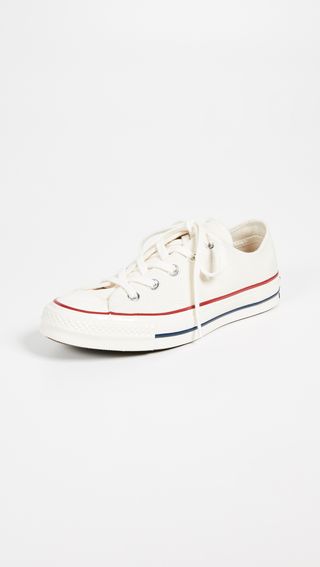 white Converse sneakers with red and blue stripes on the sole