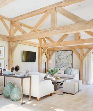 Country living room with wooden beams, white walls and TV