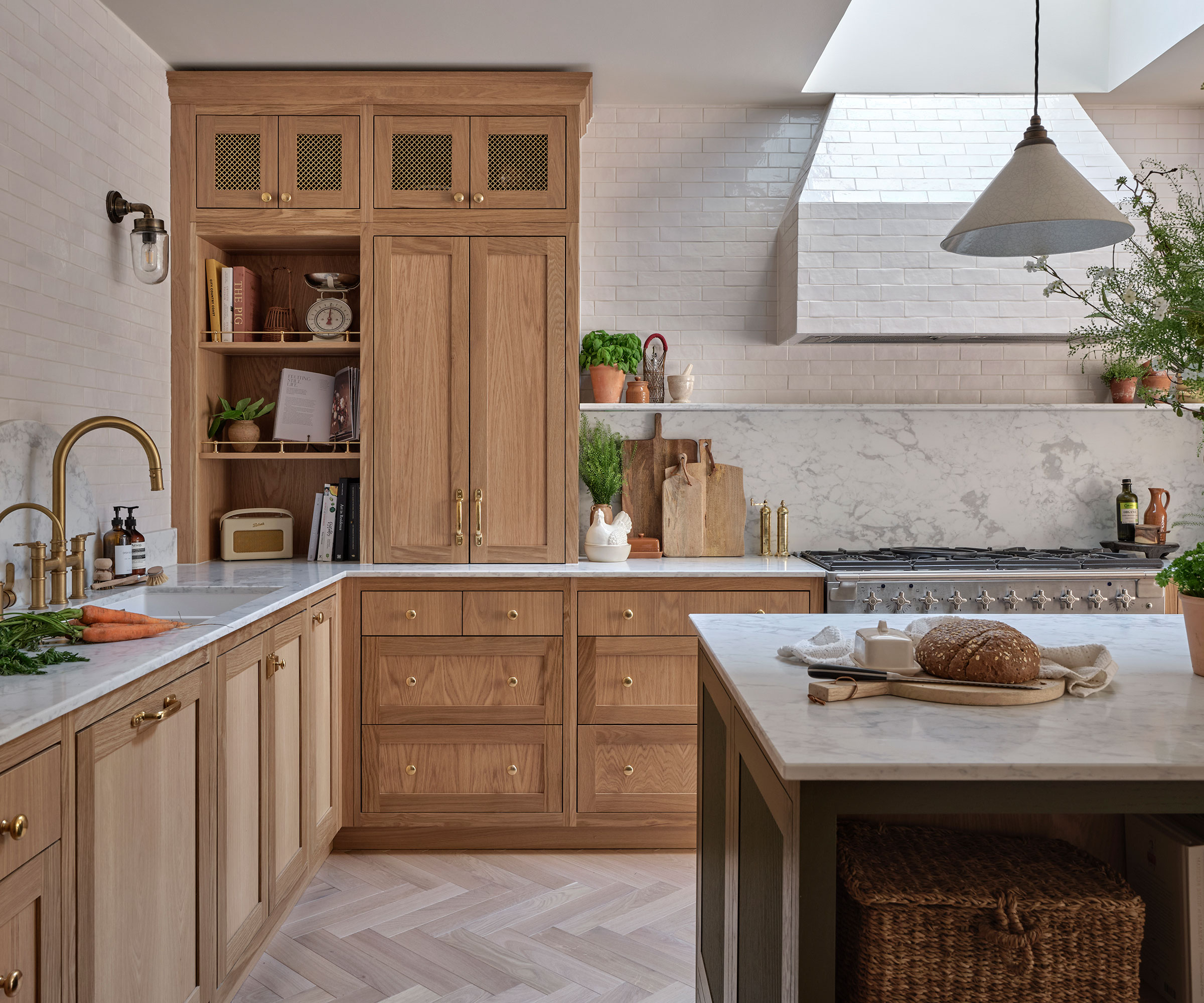 base wooden kitchen with herringbone wooden flooring and marble worktops