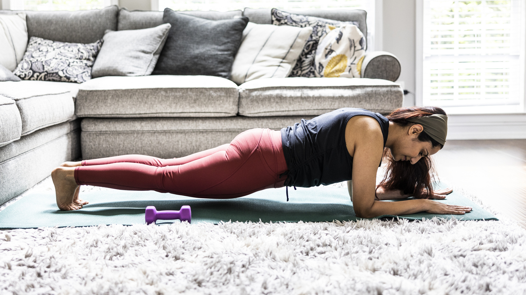 Woman performs plank exercise at home