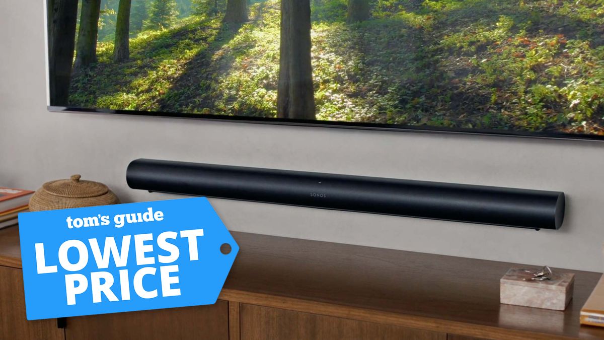 Sonos Arc soundbar attached to a wall under a TV with a Tom&#039;s Guide deal badge attached