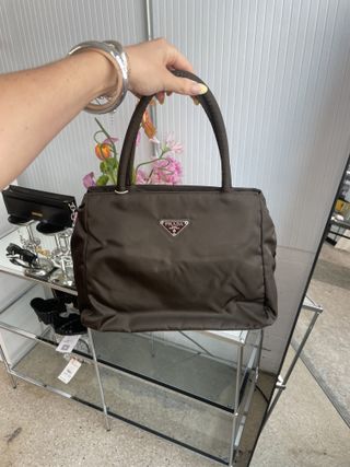 Editor holding a brown Prada Tessuto tote from Vestiaire Collective.