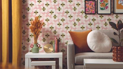 Bedroom with floral wallpaper, bed, orange bedside table and bobbin lamp.