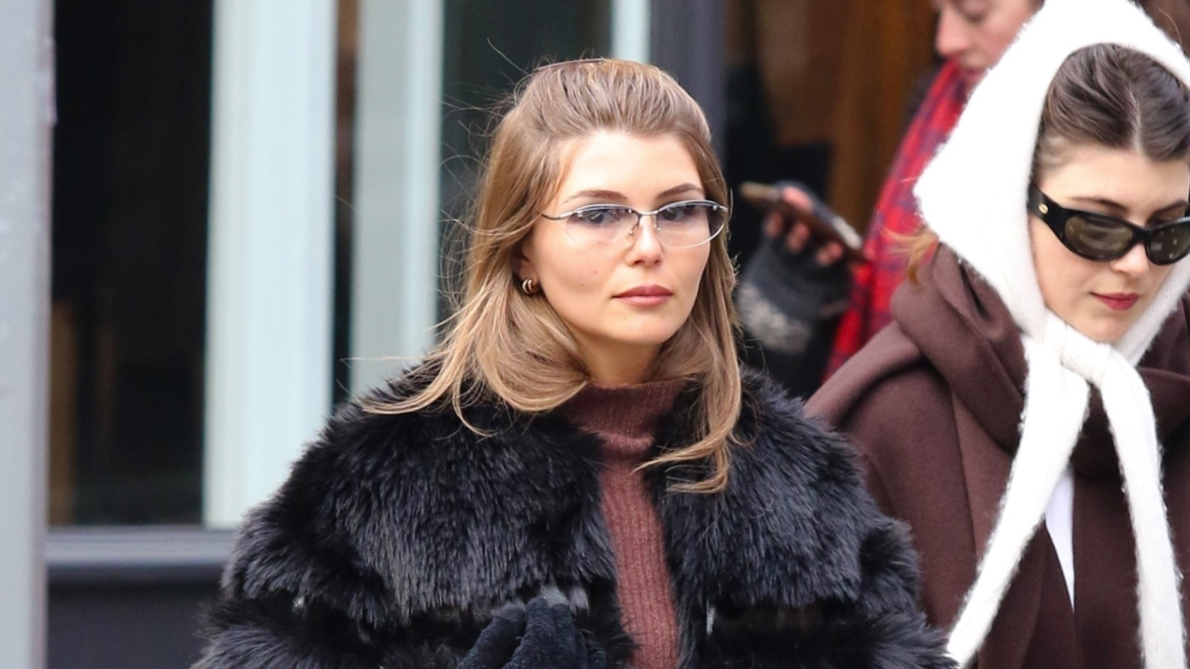 Olivia Jade wearing a black fur coat, brown turtleneck, jeans, a structured frame bag, and black block-heel ankle boots