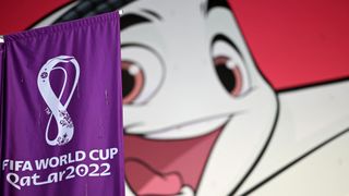 Qatar 2022 mascot La'eeb and flag
