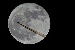 Airplane Flies by the Supermoon