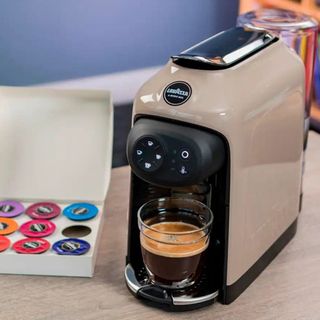Lavazza Idola coffee machine at home with selection of coffee pod capsules in box