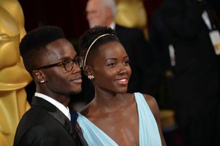 Actress Lupita Nyong'o (R) and brother Peter Nyong'o, Jr. attend the Oscars held at Hollywood & Highland Center on March 2, 2014 in Hollywood, California.