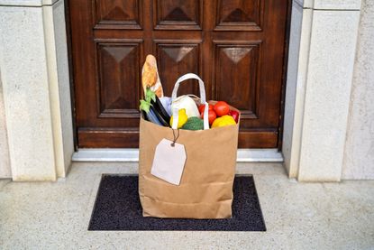 A bag of groceries on a front porch.