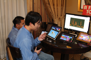 Two of Intel's engineers setting up power tests on four tablets.