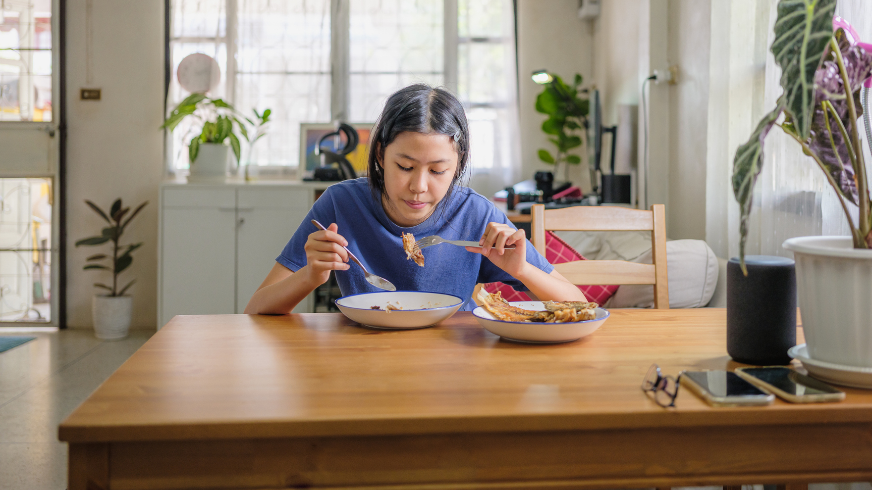 Woman sitting at kitchen table eating