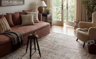 A rug sits on the floor in a well-dressed living room.