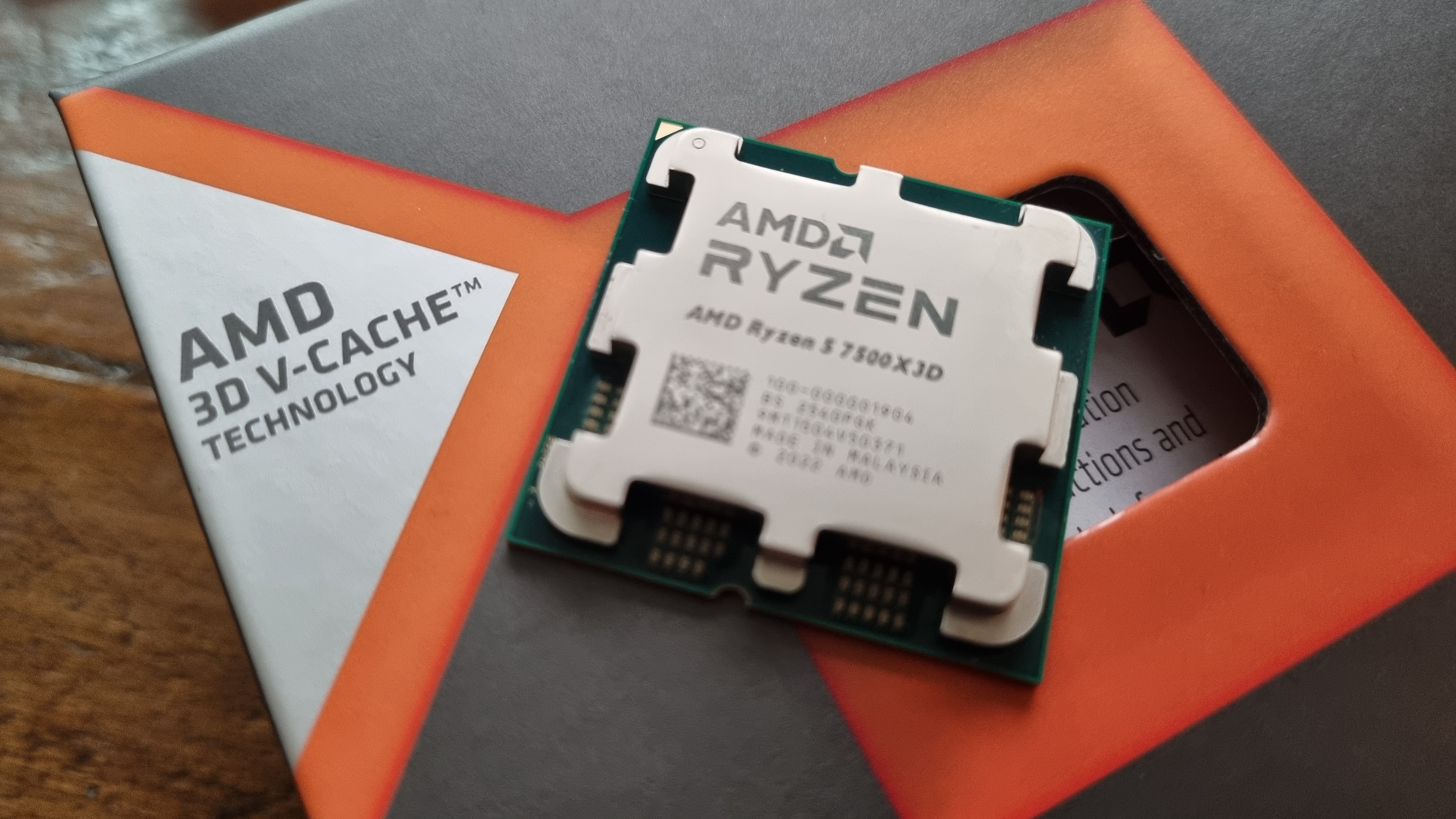 An AMD Ryzen 5 7500X3D CPU on top of its packaging