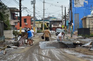People clean the streets in Toa Baja, Puerto Rico, on Sept. 22, 2017.