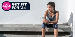 Woman sitting on bench in athleisure using a fitness app