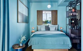 Hotel bedrooms with turquoise walls and bedding, copper wall lamps and mauve washstand