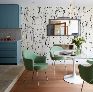 a dining room with a patterned wallpaper