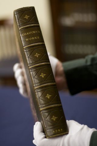 Associate curator Harold Forbes holds the 1561 copy of Chaucer that the poem was discovered in.