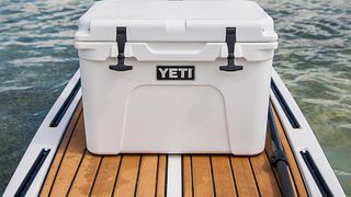 Yeti Tundra 35 Cooler in White on the deck of a small boat with the rubber latches showing