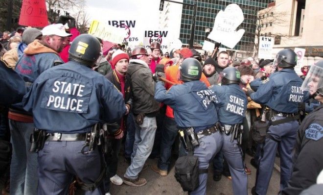 Michigan State Police push back protesters blocking a street during a rally at the Michigan State Capitol on Dec. 11.