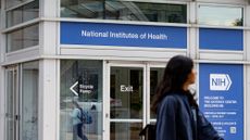 A person walks past the NIH headquarters building in Bethesda, Maryland.