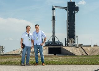 Ax-1 astronaut Eytan Stibbe (left) and Ramon Foundation director-general Ran Live stand near the SpaceX Falcon 9 rocket and Dragon capsule that will launch the Ax-1 mission from Kennedy Space Center’s Pad 39A on April 8, 2022.