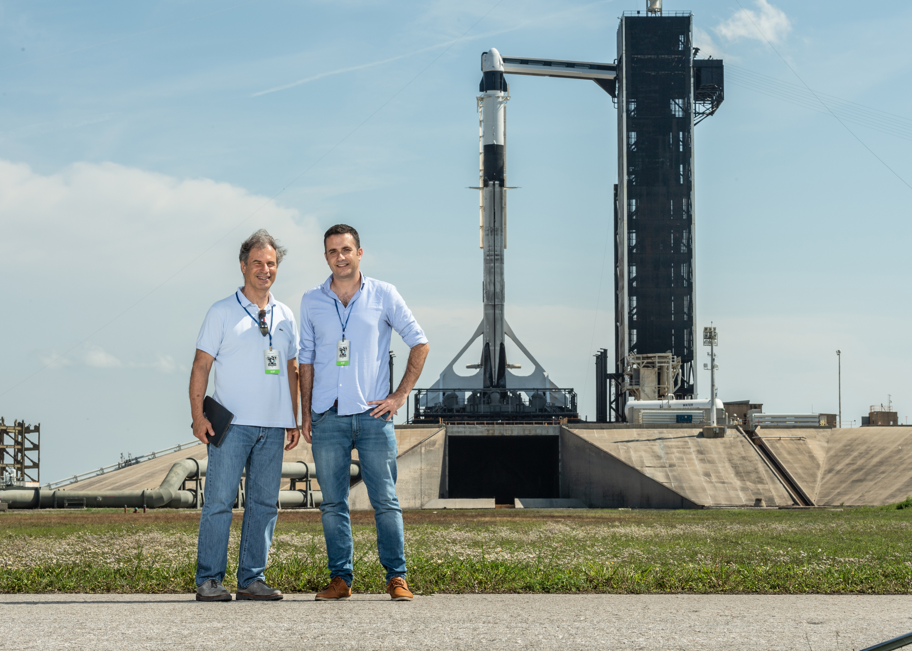 Ax-1 astronaut Eytan Stibbe (left) and Ramon Foundation director Ran Live stand next to the SpaceX Falcon 9 rocket and Dragon capsule to introduce the Ax-1 mission from Kennedy Space Center’s Pad 39A on April 8, 2022.