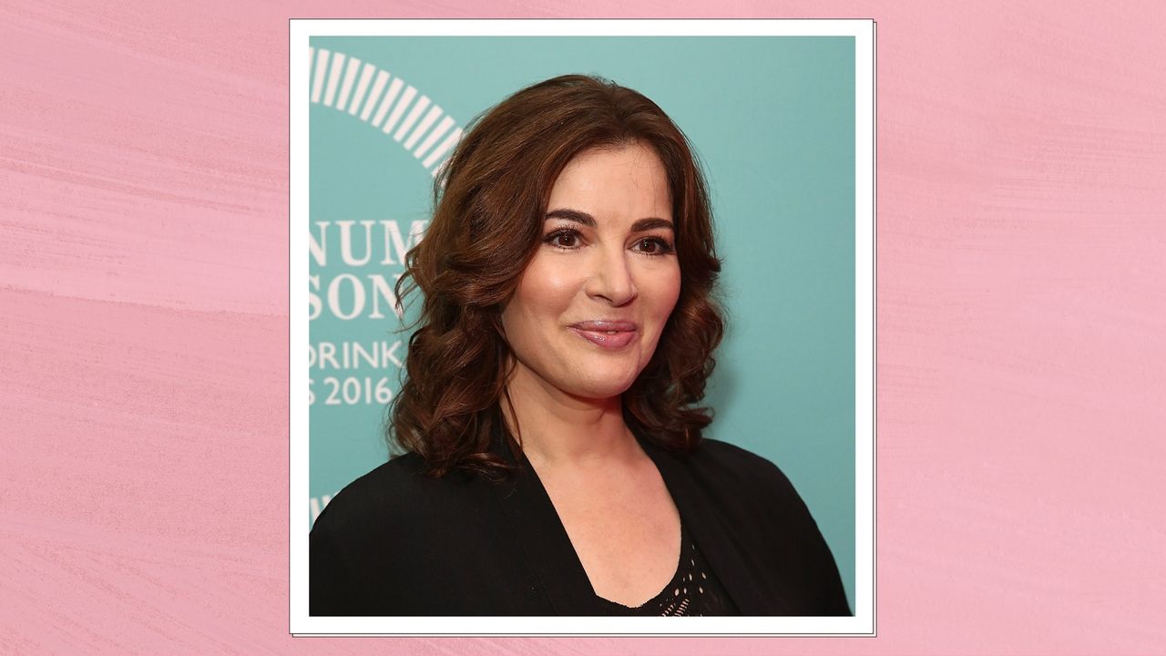 Portrait of Nigella Lawson smiling with curly brunette hair and wearing a black cardigan, on a pink watercolour background