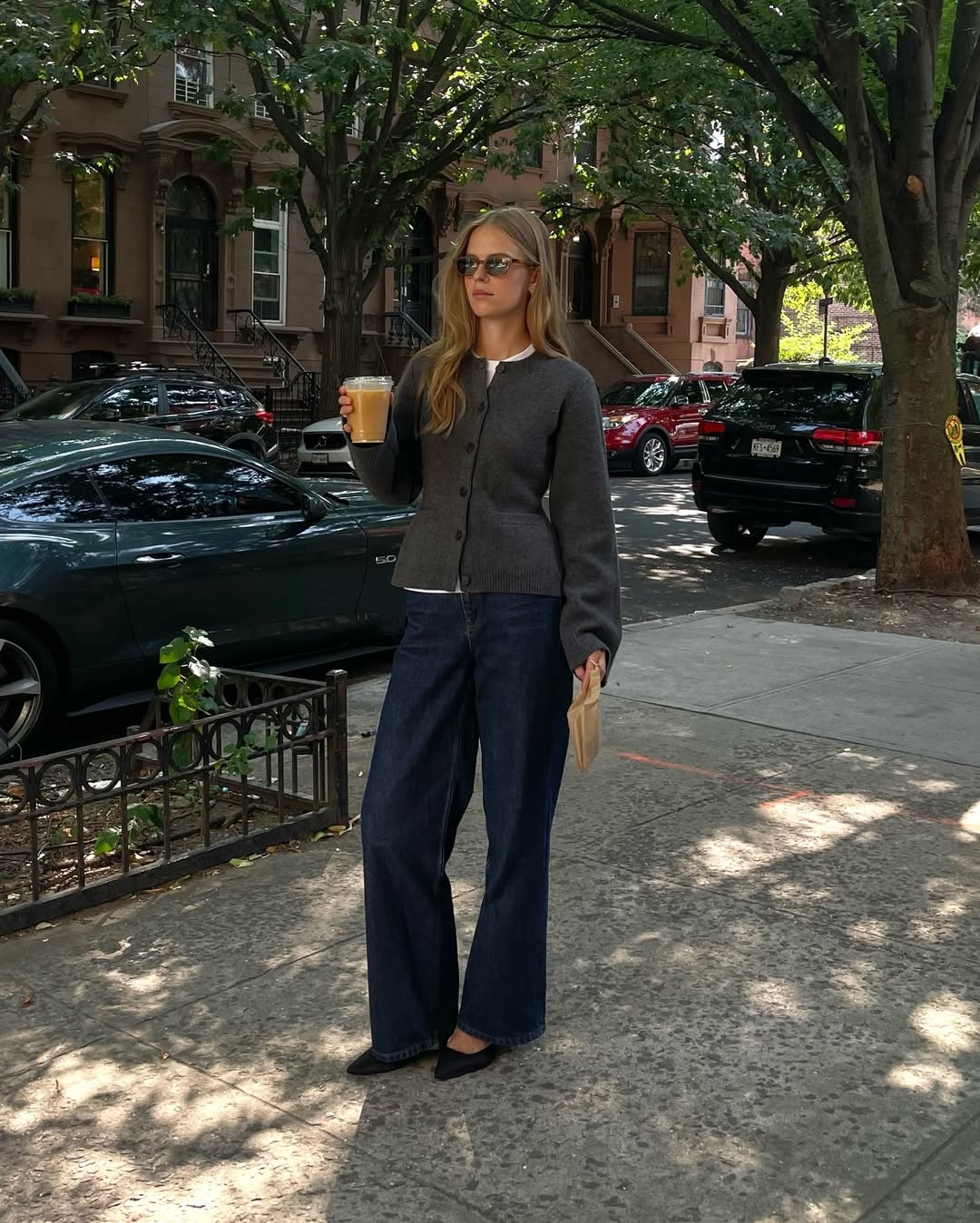 @claradyrhauge wears a grey waisted cardigan with dark indigo jeans and black pointed-toe flats