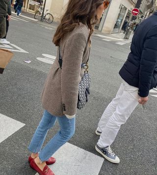 Woman wearing skinny jeans and red loafers.