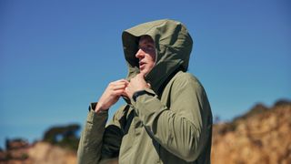 Model wears Red Equipment Pursuit changing robe with hood up