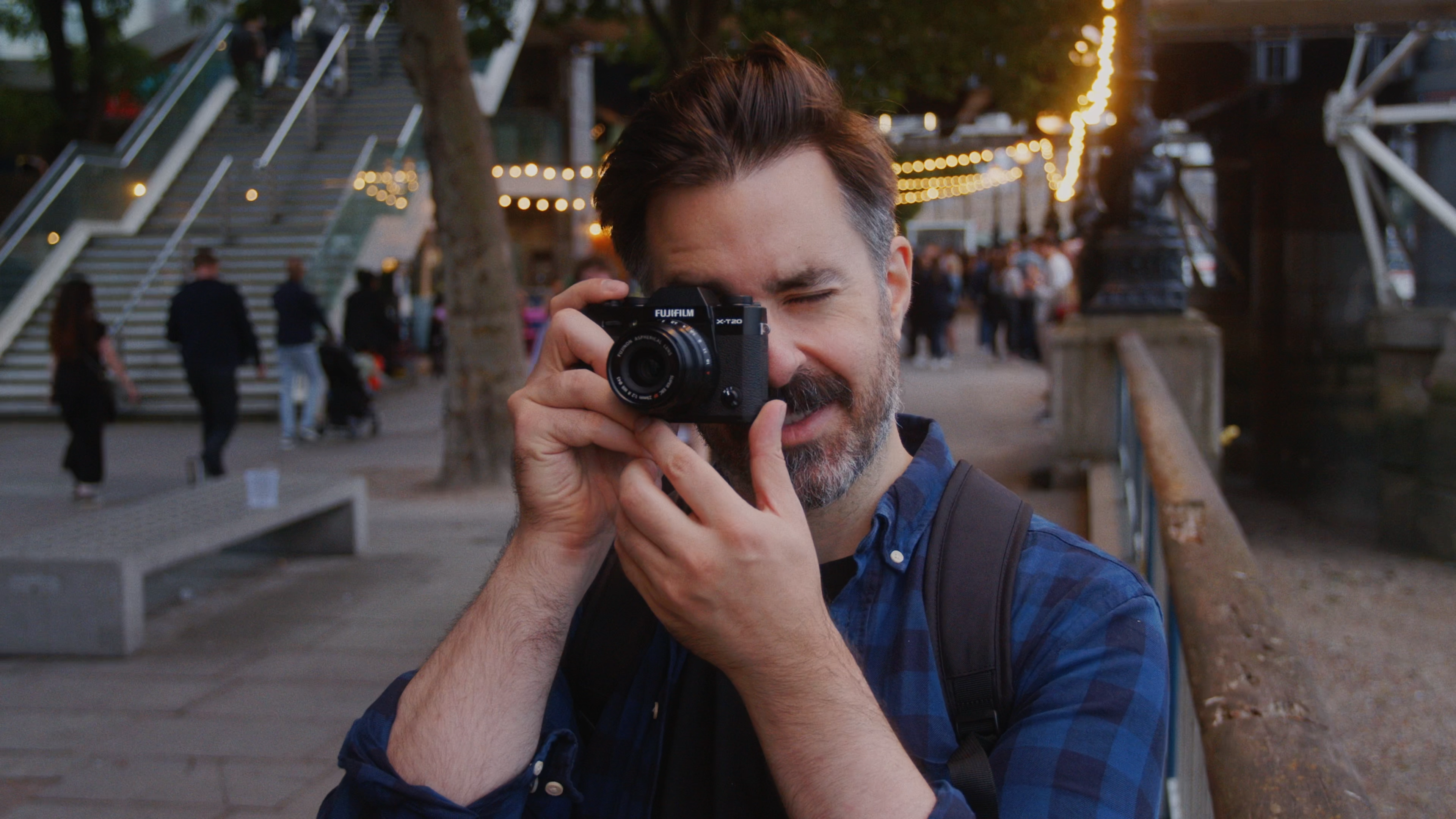 Man looking through lens finder of Fujifilm camera