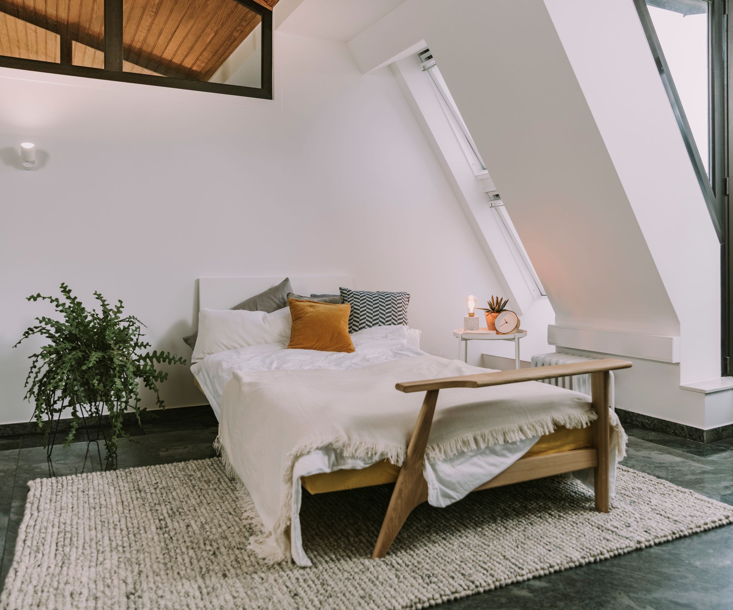 A loft conversion with white walls and a double bed