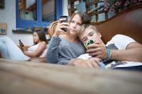 Three youth sitting on a couch (Photo by Ute Grabowsky/Photothek via Getty Images)