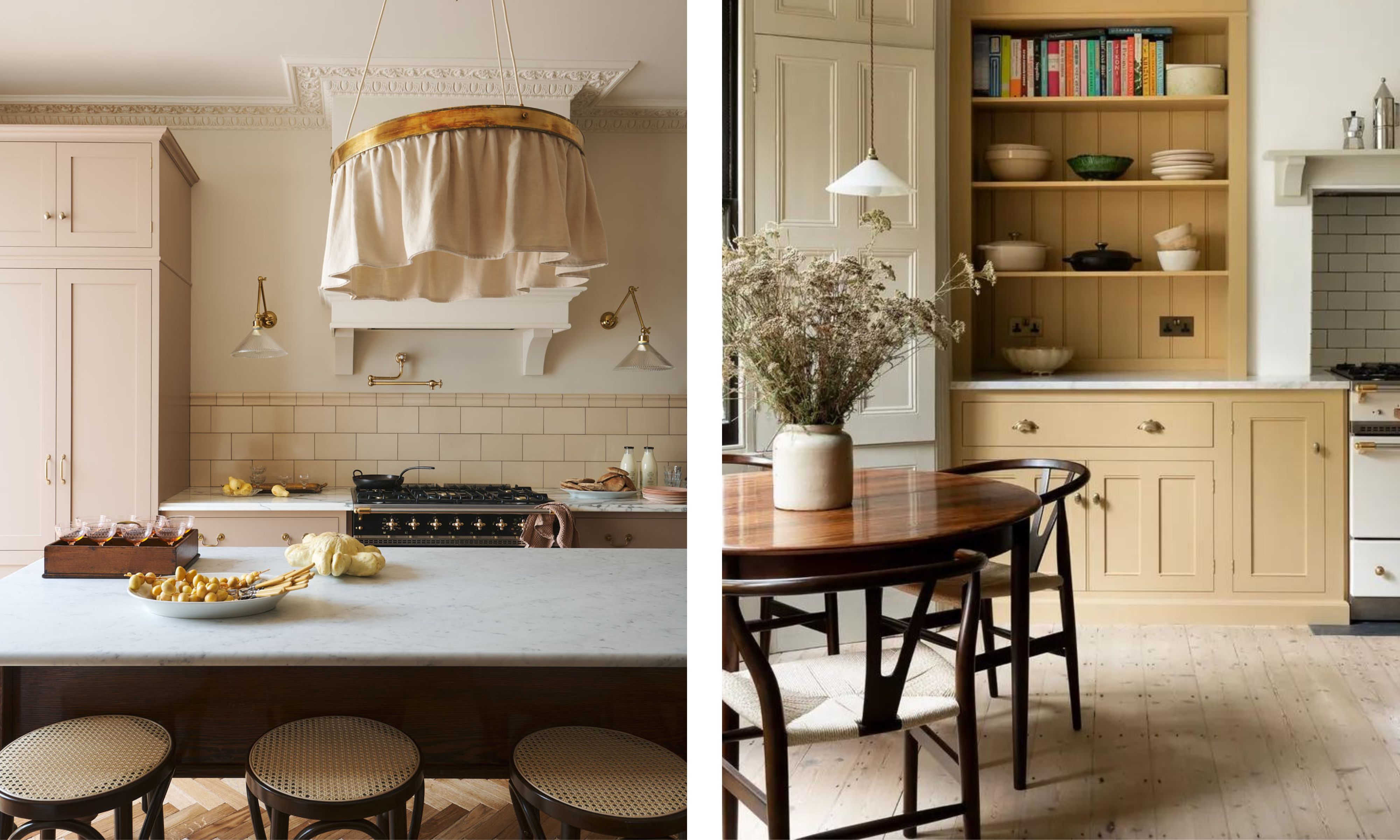 Two English-inspired kitchens showcasing warm, timeless design. The left kitchen features blush pink cabinetry, brass fixtures, a marble countertop, and a large fabric-draped pendant light above a central island with cane stools. The right kitchen displays mustard yellow cabinetry with open shelving, natural wood furniture, and a vase of dried flowers, evoking a cozy, heritage-inspired feel.