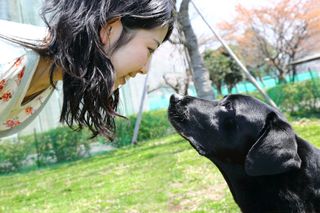 woman gazing into black lab's eyes