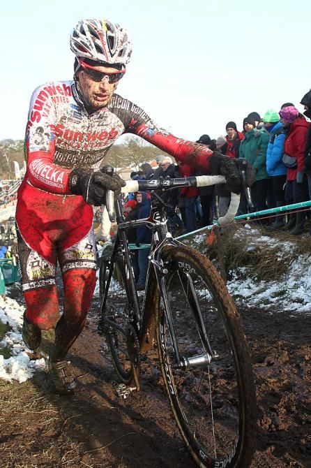 Kevin Pauwels pushes his bike to a podium placing
