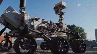 a six-wheeled rover looks up at the moon in the daytime sky.