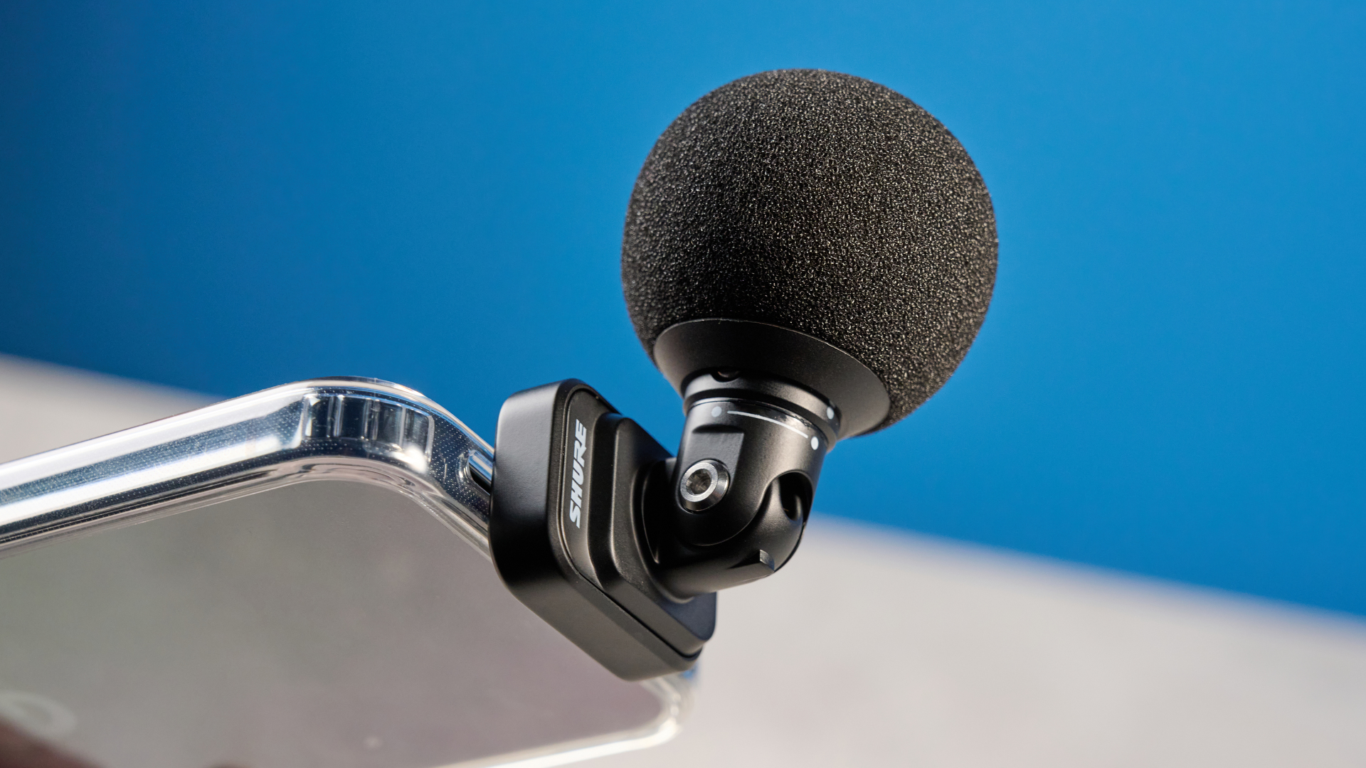 the shure mv88 usb-c microphone photographed against a blue tom's guide background and shown connected to a google pixel 10 pro