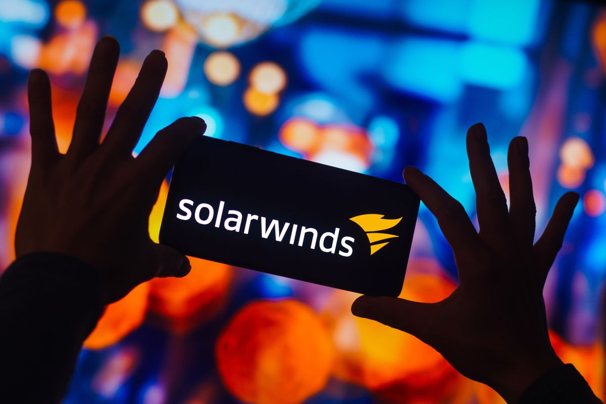 SolarWinds Corporation logo is displayed on a smartphone screen with blurry multi-colored background