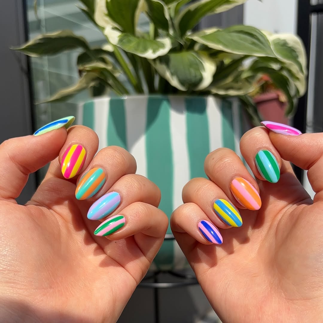 fun retro stripe nails next to a flower pot