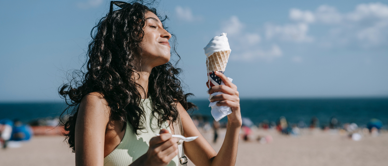 Image of woman on a beach with a melting ice cream cone