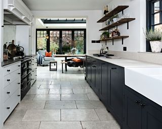 Monochrome galley kitchen with stone flooring and plenty of natural daylight