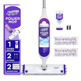 A purple and white Swiffer Powermop with a matching cardboard box. Two cleaning pads, a bottle of cleaning solution, and two batteries beside it. 