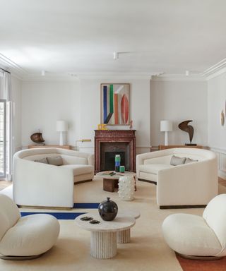 contemporary all white living room with curved furniture and pops of color