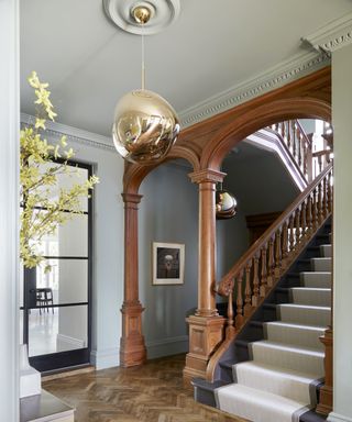 traditional entryway with modern tom dixon light