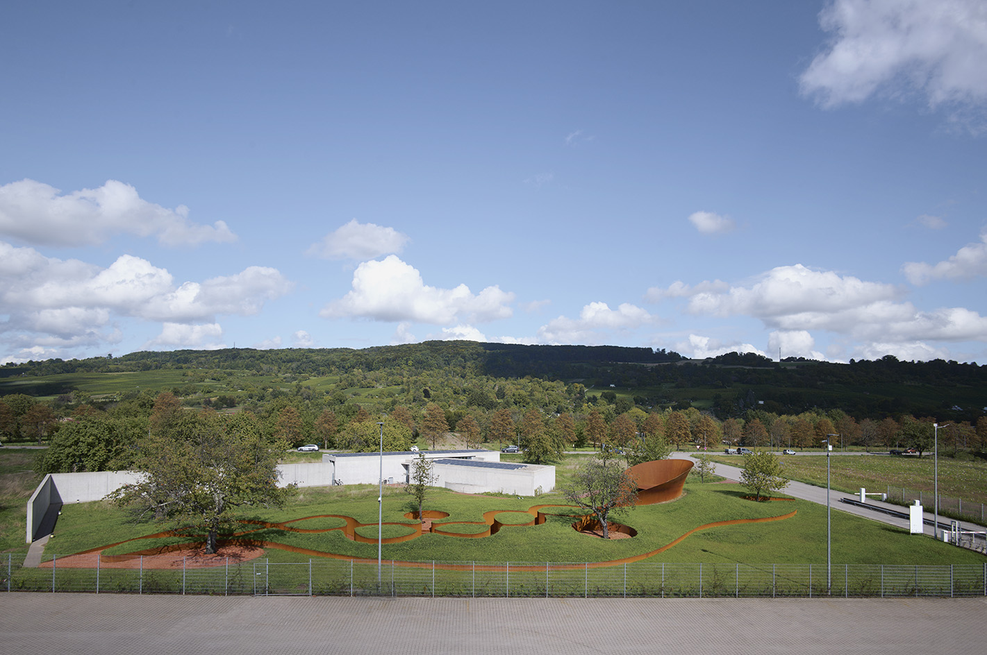 Doshi Retreat at Vitra, a pavilion made of corten steel and minimalist forms seen in the green countryside