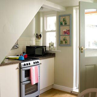 kitchen corner with noticeboard oven and pots and pans